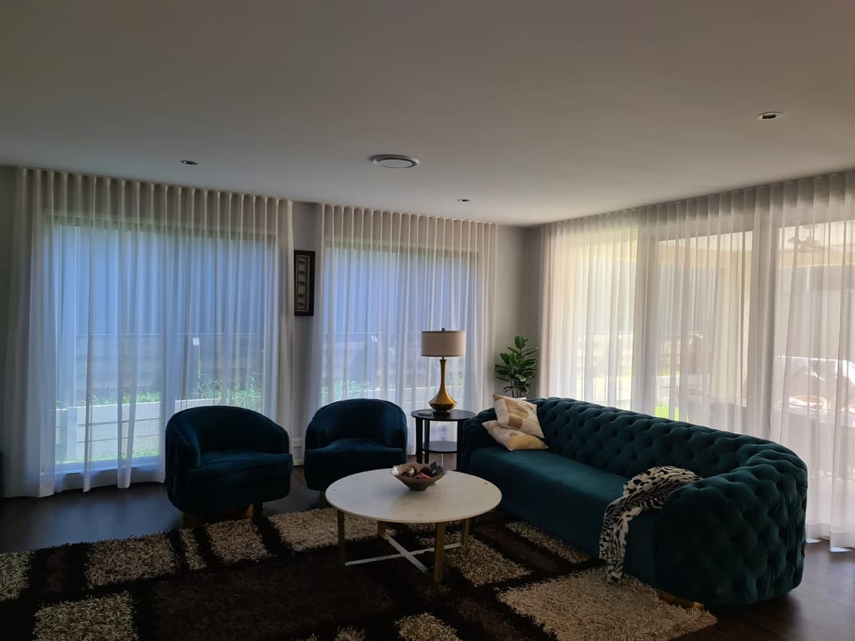 Wave-fold sheer curtains hanging in soft even folds across a living room
